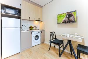 a kitchen with a refrigerator and a table with a washing machine at 1 room apartment CITY PLUS 2 in Almaty