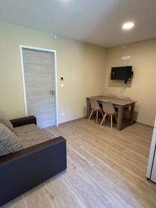 a living room with a couch and a table and a television at Sziget Apartmanház in Baja
