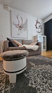 a living room with a couch and deer heads on the wall at Outapailakka K18 in Saariselka