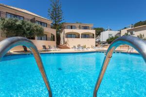 a swimming pool with blue water in a resort at Mar Hotels Alcanada in Port d'Alcudia
