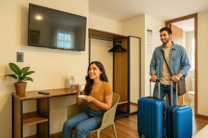 a man and a woman with luggage in a room at Mestiza Hotel Boutique in Ipiales