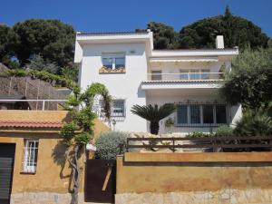 una casa blanca en una colina con árboles en Villa Jordana One Step To The Beach, en Sant Pol de Mar