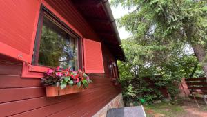 a red house with a window with flowers in a window box at Villa Limhamn - Őrbottyán in Őrbottyán