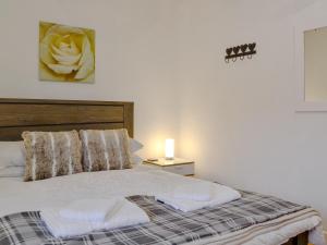 a bedroom with a bed with a flower on the wall at Katellen Cottage in Threlkeld +9 photos