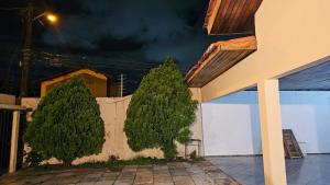 two trees on the side of a building at Península Centro histórico e praias quartos e suítes in São Luís