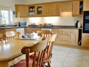 a kitchen with a wooden table and wooden cabinets at Alby Bungalow in Wetheral
