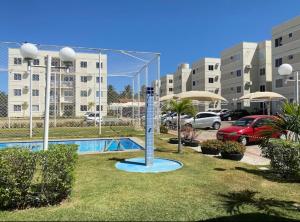 a pool in a parking lot next to a building at Apartamento Moderno & Mobiliado - Próximo ao Aeroporto, Condomínio Village Natureza in Juazeiro do Norte