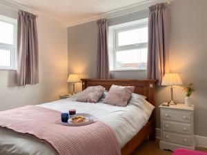 a bedroom with a bed with a plate of food on it at Smile 'N' Wave in Gorleston-on-Sea
