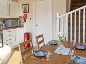 a dining room table with a vase of flowers on it at Signals Court in Scarborough