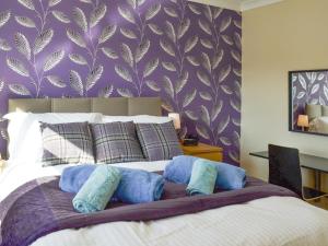 a bedroom with a large bed with blue pillows at Signals Court in Scarborough