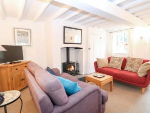 a living room with two couches and a fireplace at Broom Cottage in East Rudham