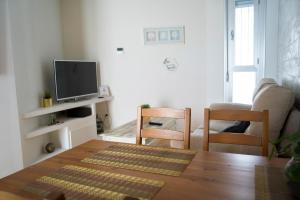 a living room with a table and a tv at BONITO APARTAMENTO a 200 metros del centro de Sevilla con piscina y parking gratis in Seville