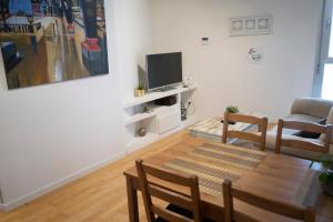 a living room with a table and a tv at BONITO APARTAMENTO a 200 metros del centro de Sevilla con piscina y parking gratis in Seville +21 photos