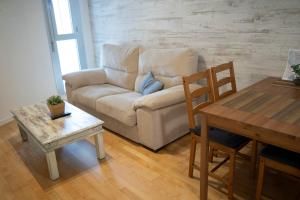 a living room with a couch and a table at BONITO APARTAMENTO a 200 metros del centro de Sevilla con piscina y parking gratis in Seville