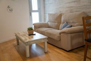 a living room with a couch and a coffee table at BONITO APARTAMENTO a 200 metros del centro de Sevilla con piscina y parking gratis in Seville