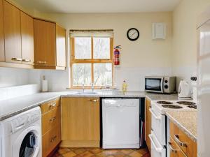 a kitchen with a white dishwasher and a microwave at Moy in Taynish