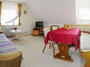 - un salon avec une table et une télévision dans l'établissement Obsthof Vogthof, à Lautenbach