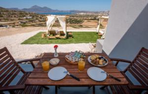 普拉卡米洛斯Esperos Panoramic View Suites 2的一张桌子上摆放着食物的木桌