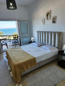 a bedroom with a bed with a view of the ocean at Turquoise view la marsa in El Haouach