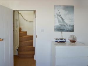 a hallway with a staircase with a picture of a sailboat at Jicklings in Wells next the Sea