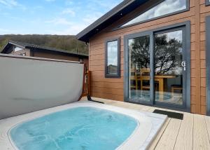a hot tub on the deck of a house at Cheddar Woods Resort And Spa in Cheddar