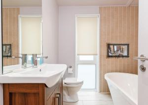 a bathroom with a sink and a toilet and a tub at Cheddar Woods Resort And Spa in Cheddar