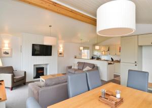 a living room with a dining table and a living room with a fireplace at Cheddar Woods Resort And Spa in Cheddar