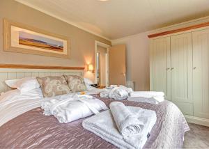 a room with a bed with towels on it at Cheddar Woods Resort And Spa in Cheddar