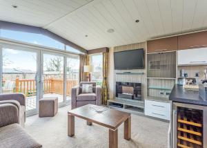 a living room with a fireplace and a tv at Cheddar Woods Resort And Spa in Cheddar