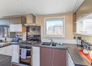 a large kitchen with a sink and a window at Cheddar Woods Resort And Spa in Cheddar