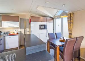 a kitchen with a table and chairs in a room at Cheddar Woods Resort And Spa in Cheddar