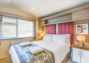 a bedroom with a bed with two pillows on it at Cheddar Woods Resort And Spa in Cheddar