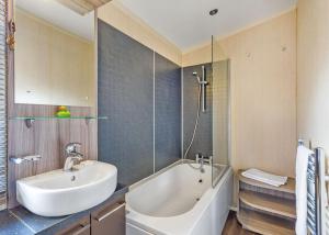 a bathroom with a tub and a sink and a bath tub at Cheddar Woods Resort And Spa in Cheddar