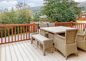 a wicker table and chairs on a wooden deck at Cheddar Woods Resort And Spa in Cheddar