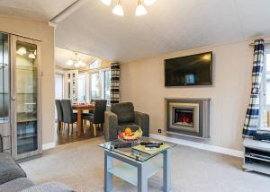 a living room with a fireplace and a table at Cheddar Woods Resort And Spa in Cheddar