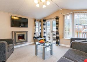 a living room with a couch and a fireplace at Cheddar Woods Resort And Spa in Cheddar