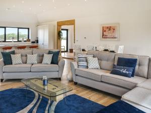 a living room with two couches and a table at Metfield in Scratby