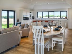 a kitchen and living room with a table and chairs at Metfield in Scratby