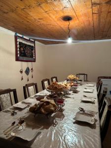 a long table in a dining room with plates and utensils at GeshouseAselBarskoon in Barskoon +48 photos