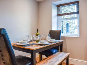 a dining room table with glasses and a bottle of wine at Wallthwaite Cottage in Threlkeld