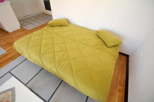 uma grande cama amarela num quarto em Apartment Mirjana em Budva
