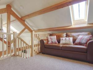 un sofá de cuero marrón en una habitación con ventana en Fferam Gorniog, en Holyhead