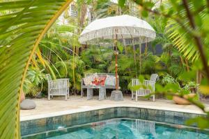 a patio with a table and chairs and an umbrella at Villa Célestine in Saint-Paul