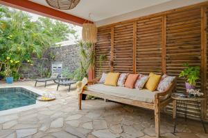 a patio with a couch next to a pool at Villa Célestine in Saint-Paul +5 photos