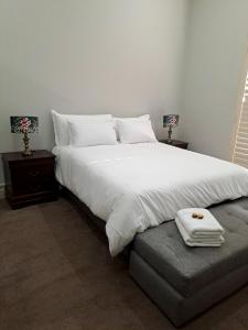 a bedroom with a large white bed and a couch at Keerweder in Ceres