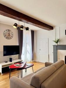 a living room with a couch and a table at Le Saint Melaine, Hyper centre de Rennes in Rennes