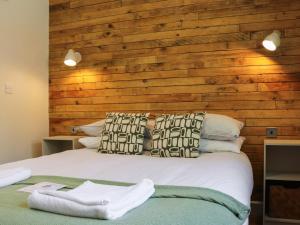 a bedroom with a wooden accent wall and a bed at Dinas Lodge - Uk47607 in Caernarfon