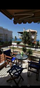 ein Tisch und Stühle auf einer Terrasse mit Blick auf das Meer in der Unterkunft Purple_Rose_Apartment in Chaniotis