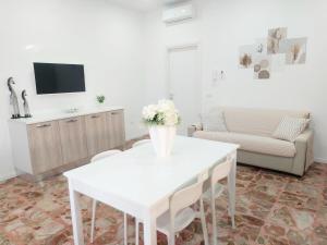 a living room with a white table and a couch at Modestina's house in Mondragone