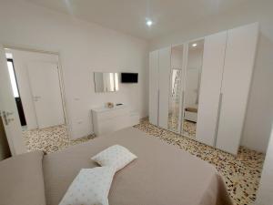 a white room with a bed and a mirror at Modestina's house in Mondragone